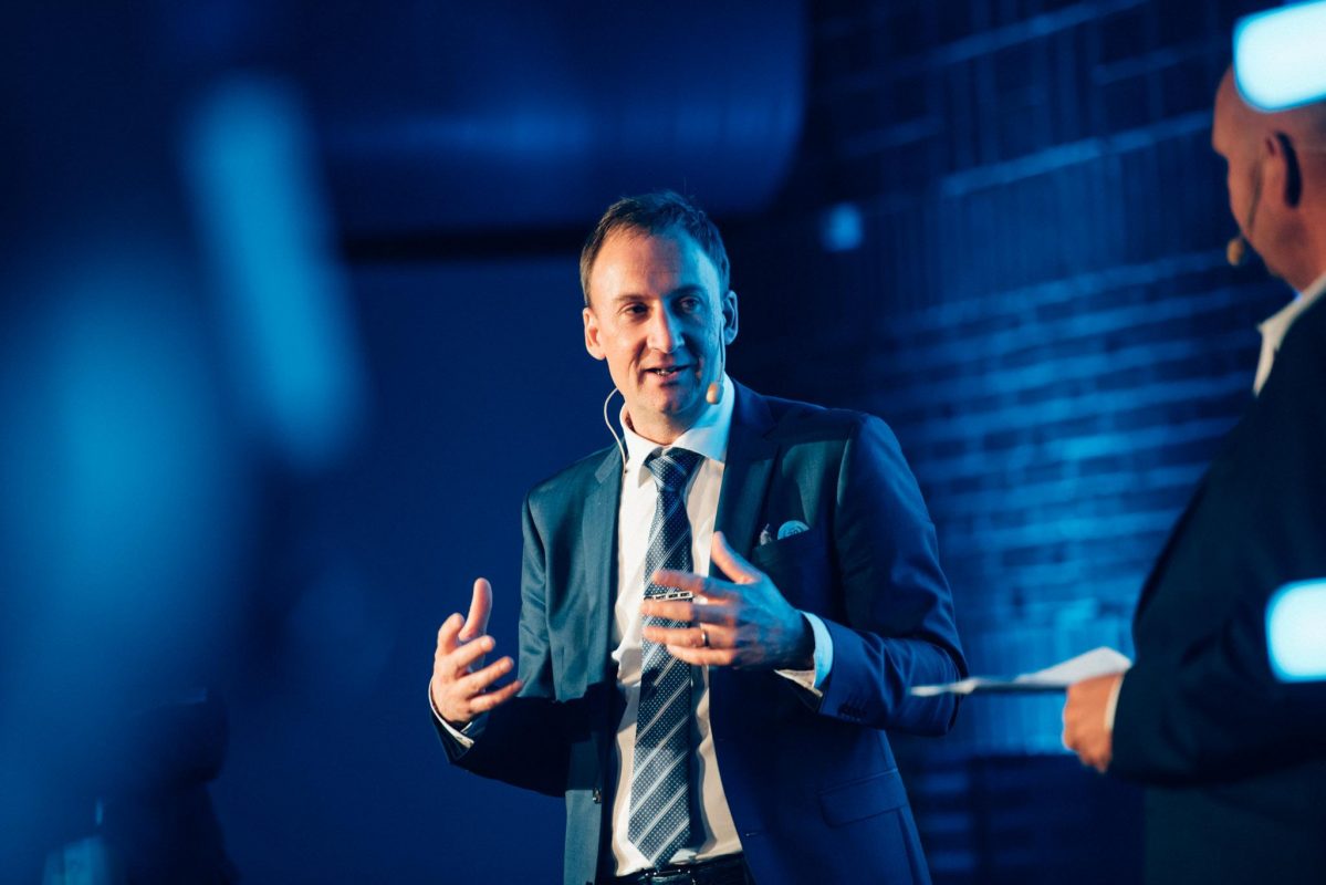 man standing on stage talking