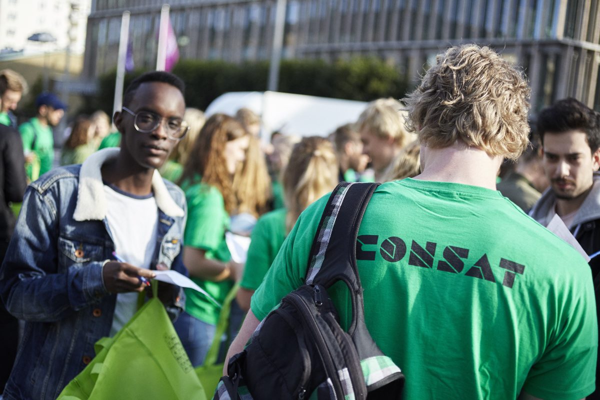 lots of people staning in green consat t-shirts