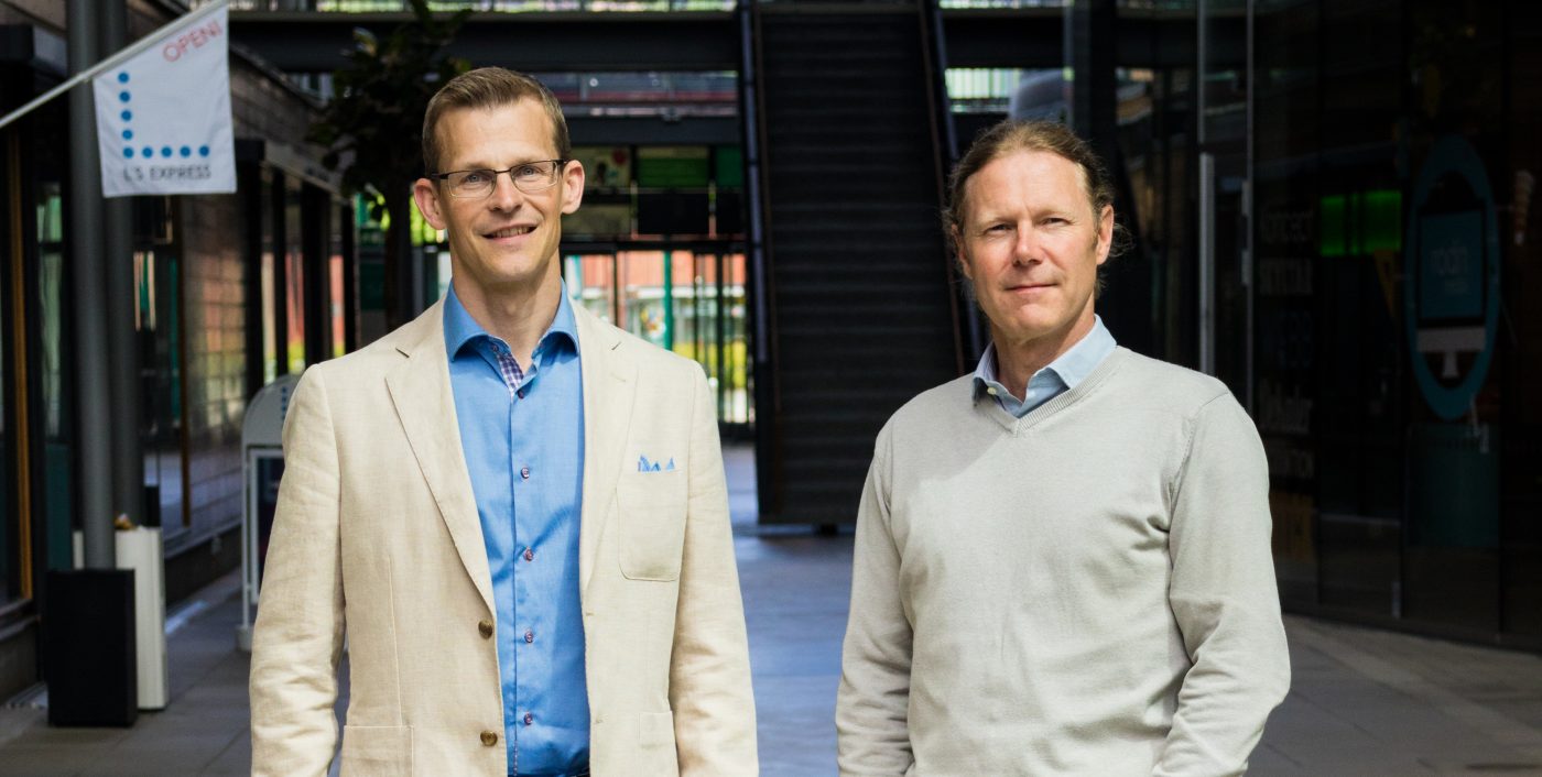 two men standing in a large hall