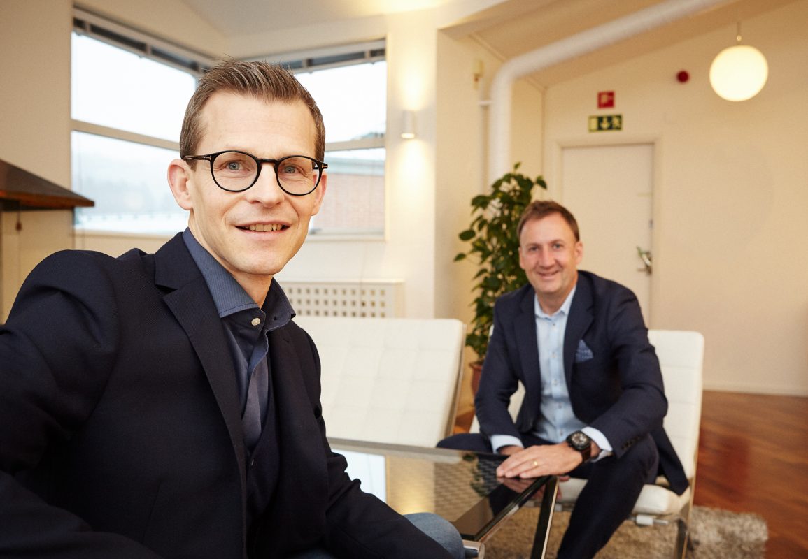 two men sitting and looking at the camera