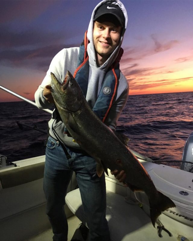 man holding a fish on a boat