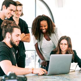 five people lokking at a computer screen