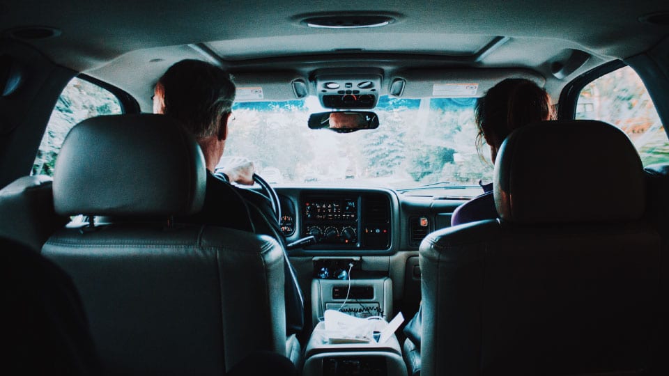 two people in the front seat of a car