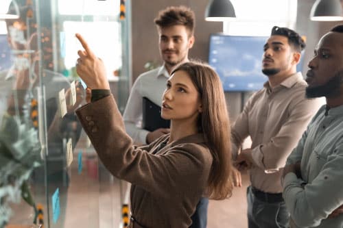 three people lokking at a whiteboard