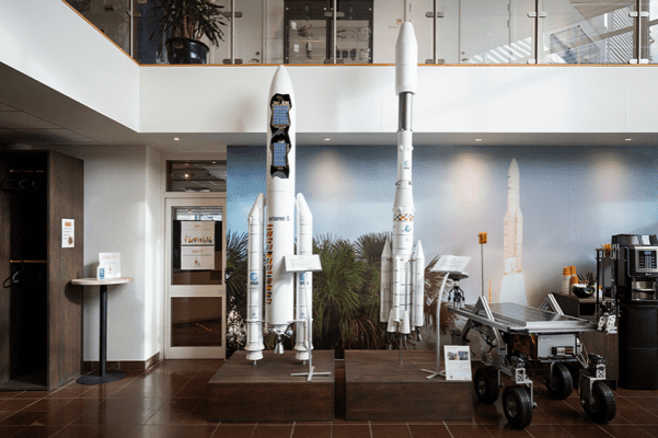 Two minature rockets standing in a large room